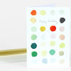 A folded greeting card with multicolored paint dots and the handwritten words "happy birthday" on the front.