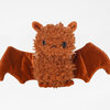 A small brown plush bat with fuzzy fur, black bead eyes, small pointed ears, and outstretched velvety wings.
