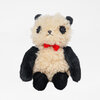 A small plush panda stuffed animal with cream fur, black ears, black arms and legs, embroidered facial features, and a red bow tie.