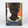 A hardcover book with an illustrated cover showing two girls in cloaks facing each other around the title "SNOW & ROSE," with "Emily Winfield Martin" printed at the bottom.