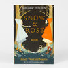 A softcover book titled "Snow & Rose" by Emily Winfield Martin with illustrated cover art of two girls in cloaks facing each other in a forest and a small key near the bottom.