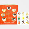 A red board book titled "A Celebration of Love" and "This is a GIFT for YOU" with heart-shaped cutout windows showing illustrated children on the cover, by Emily Winfield Martin.