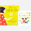 A children’s picture book with a bright yellow cover showing a girl in a red polka-dot dress holding a white flower, with the title text "This Is a Gift for You" and the author name "Emily Winfield Martin," alongside an open interior spread showing two children reading in a library.