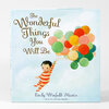 A hardcover book titled "The Wonderful Things You Will Be" by Emily Winfield Martin, with an illustration of a child holding a bunch of colorful balloons on the cover.
