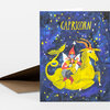 A folded greeting card featuring the word "CAPRICORN" above a colorful illustrated goat and rider surrounded by stars.