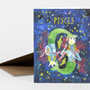 A greeting card with the word "PISCES" in yellow at the top and an illustrated pair of fish and mermaid figures among stars and coral-like shapes.