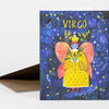A folded greeting card with the word “VIRGO” on the front, featuring a colorful illustrated figure in a yellow dress with pink wings surrounded by stars.