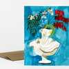 A folded greeting card with a colorful illustration of a white classical bust filled with flowers and leaves on a bright blue background.