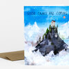 A folded greeting card with the text "GOOD THINGS ARE COMING" above an illustration of a mountain topped by a small house, pine trees, clouds, and a blue sky.