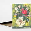 A folded greeting card with an illustration of a white vase holding colorful wildflowers and the text "Happy Birthday!" on the front.