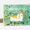 A folded greeting card with the text "HELLO BEAUTIFUL!" and an illustration of a white-and-tan dog surrounded by a colorful leafy floral pattern.
