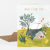 A folded greeting card with the text "HELLO, I LOVE YOU." above an illustration of a white bear sitting among plants, flowers, rocks, and mushrooms, with a brown envelope behind it.