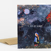 A folded greeting card with an illustrated dark night scene and the text "I AM SO SORRY." on the front, shown with a kraft paper envelope.