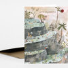 A folded greeting card with the text "LET'S CELEBRATE!" and an illustrated scene of tiered rocky pools filled with tiny figures and tropical plants.