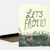 A folded greeting card with the text "LET'S FROLIC!" in large stylized letters above a dense illustrated field of flowers and plants.