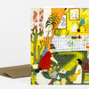 A folded greeting card featuring a colorful illustration of people playing mini golf indoors among potted plants, framed art, and a bright yellow-green course.