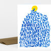 A folded greeting card with a blue illustration of many small human figures arranged like a tree or mountain topped by a yellow circle, with a brown envelope partially visible behind it.