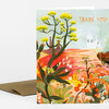 A folded greeting card with a colorful desert landscape illustration and the words "THANK YOU!" printed at the top right.