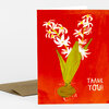 A greeting card with a red front showing a vase of white flowers and the words "THANK YOU!" in white.