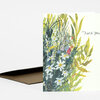 A folded greeting card with a wildflower illustration on the front and the words "Thank You" in script.