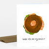 A folded greeting card with an illustrated bagel sandwich and the text "Will you be my bagel?" on the front.