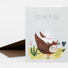 A folded greeting card with the text "YOU ARE MY OWL." and an illustration of a brown owl carrying a small white animal among plants.