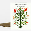 A folded greeting card with the text "YOUR FAMILY TREE is GROWING" above a colorful illustrated tree made of green branches, white flowers, and small red birds.