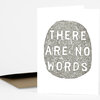 A folded greeting card with a gray woodblock-style oval print reading "THERE ARE NO WORDS" in large white capital letters.