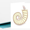 A folded greeting card with a stylized dog sitting on top of a spiral staircase illustration.