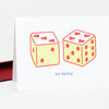 A folded greeting card shows two illustrated dice with heart pips on top and the words "so lucky" underneath.