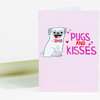 A folded pink greeting card with a cartoon pug wearing a bow tie and the text "PUGS AND KISSES" with small hearts.