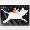 A postcard set with an illustrated white cat carrying two girls across a black sky with yellow stars, shown in clear plastic packaging.