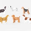 A set of six dog-shaped desk calendars in different breeds and colors, each printed with a small monthly calendar grid on the body.