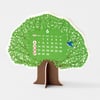 A tree-shaped desk calendar with green leafy branches, a brown trunk, a large "6" at the top, a small bird illustration, and a month grid with Sunday through Saturday labels and numbered dates.