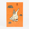 An orange postcard-style print showing a cartoon wizard or clown with a striped pointed hat riding a skateboard, with small doodles including a flower, a skull, and patterned semicircles.