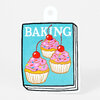 A die-cut sticker shaped like a book cover with the word "BAKING" and three frosted cupcakes topped with cherries.