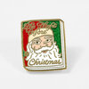 A gold-tone enamel pin shaped like a book cover, featuring Santa Claus and the text "The Night Before Christmas."