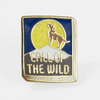 A rectangular enamel pin with a gold border, a howling dog silhouette in front of a yellow circle, and the text "CALL OF THE WILD" across the lower half.