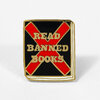 A square enamel pin with a gold outline shows a red X over a black field and the raised gold text "READ BANNED BOOKS".
