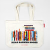An off-white canvas tote bag with two handles and a printed stack of colorful book spines above the bold text "READ BANNED BOOKS" and the smaller text "IDEAL BOOKSHELF".