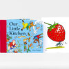 A hardcover book titled "Our Little Kitchen" by Jillian Tamaki with a blue illustrated cover, red spine, and a white page showing a large strawberry illustration and the handwritten text "HA HA!".