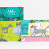 A colorful illustrated book titled "Aldo Ghost Dog" with a gray dog on the cover and another interior illustration showing the dog carrying a red ball.