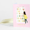 A pink greeting card with an illustration of a girl reaching toward a bookcase and the text "I WOULD PICK YOU" on the front, shown with a pale envelope.