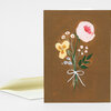 A folded greeting card with a bouquet illustration on a brown cover, featuring pink, yellow, white, and blue flowers tied with a white ribbon.