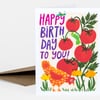 A folded birthday greeting card with the text "HAPPY BIRTH DAY TO YOU!" and a colorful illustration of tomatoes, a chicken, plants, and a caterpillar.