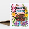 A folded greeting card shows a two-tier chocolate cake surrounded by flowers, butterflies, a frog, and a rabbit, with the words "HAPPY BIRTHDAY" on black banners.