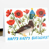 A folded greeting card featuring an illustrated duck wearing a blue party hat among red flowers, with the text "HAPPY HAPPY BIRTHDAY!" on the front.