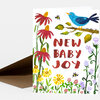 A folded greeting card with a watercolor floral design, a blue bird on a branch, and the text "NEW BABY JOY" on the front.