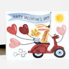 A folded greeting card shows a cartoon rabbit riding a red scooter with heart-shaped balloons and a banner that reads "HAPPY VALENTINE'S DAY!"