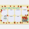 A strawberry-themed weekly meal planner notepad with rounded day boxes labeled Monday, Tuesday, Wednesday, Thursday, Saturday, Sunday, a DATE box, and the title "ON THE TABLE THIS WEEK."
